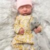 Full body silicone reborn baby boy doll Hudson sleeping in a blue outfit, showcasing the seamless silicone material.
