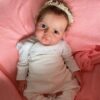 Full body silicone reborn baby girl doll Emma with grafted hair, lifelike soft skin, and realistic newborn features ready for adoption.