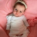 Full body silicone reborn baby girl doll Emma with grafted hair, lifelike soft skin, and realistic newborn features ready for adoption.