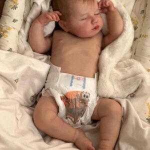 Realistic newborn silicone baby doll Asher posed sitting up, showing his flexible full limbs.