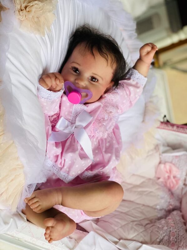 Realistic reborn toddler baby girl doll Maddie standing, with long rooted hair and open eyes.