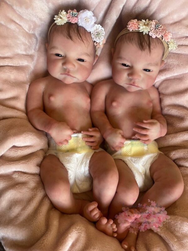 Ultra-realistic full body silicone twin baby dolls, Daisy and Riley, awake and smiling.
