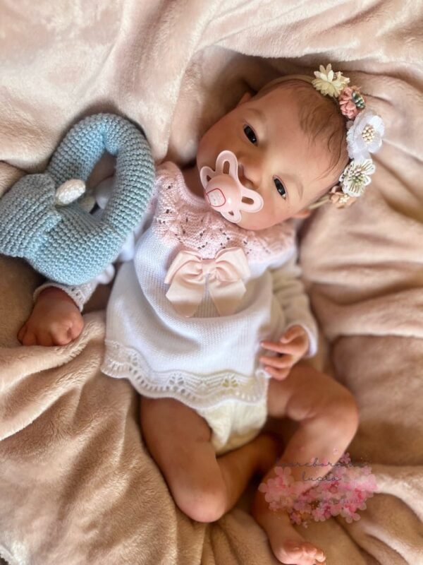 Ultra-realistic full body silicone twin baby dolls, Daisy and Riley, awake and smiling in coordinated outfits.
